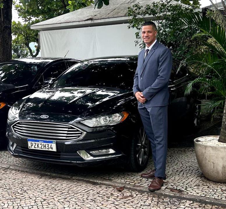 Emmanuel beside a Ford Fusion used by VTC Rio